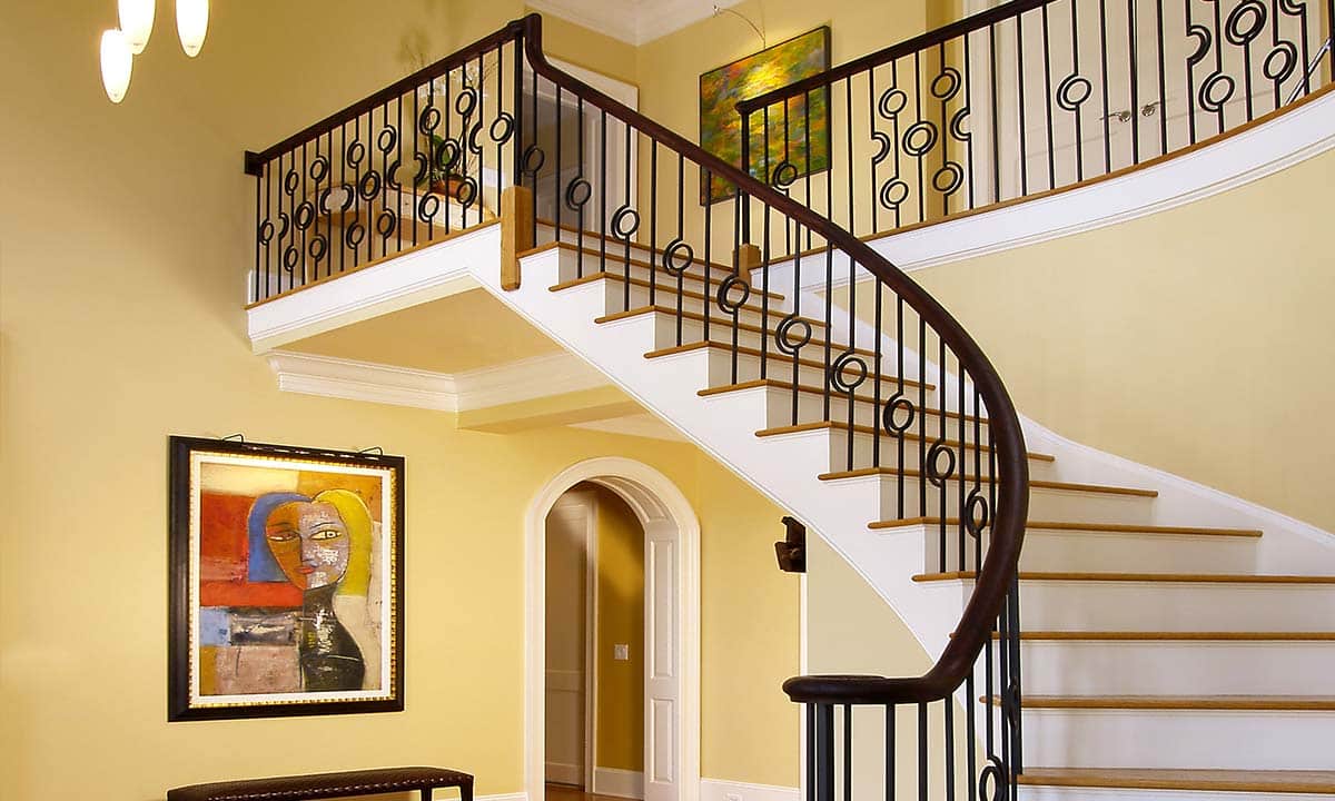 Foyer renovation showers staircase with new trim molding and modern stair rails